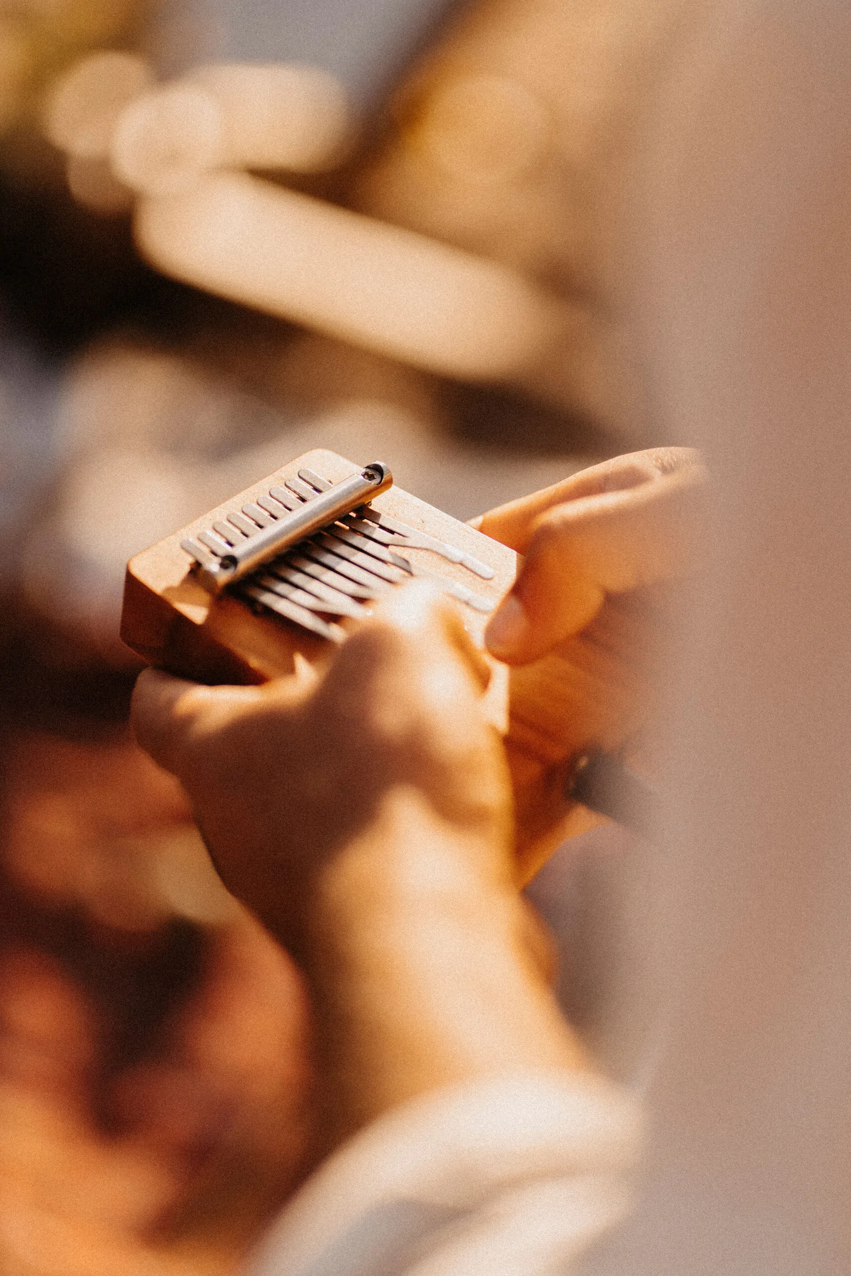 Close-up of hands playing the kalimba during a sound healing session, producing gentle, melodic vibrations for emotional and spiritual healing.